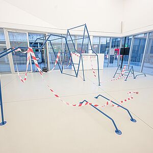 großen blaues Eisengestell mit blau/roten Baustellabsperrung zu Bild mit Baustellband