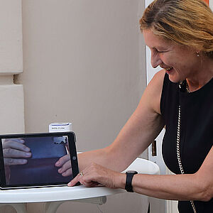 Foto von Elisabeth Wörndl mit Ipad vor dem Museumspavillon