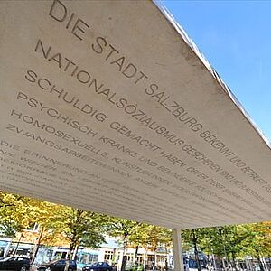 Nahaufnahme der Unterseite der Betondecke des Mahnmals mit der eingravierten Inschrift.