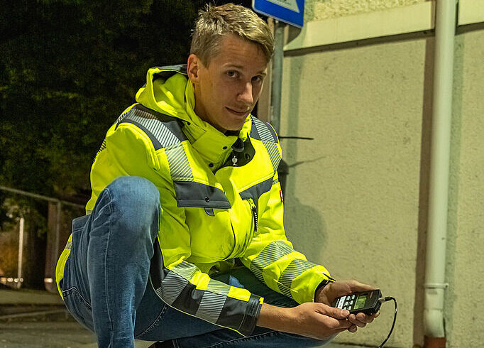 Ein Mann fuehrt gerade Wartungsarbeiten und Kontrollen bei der oeffentlichen Beleuchtung durch.