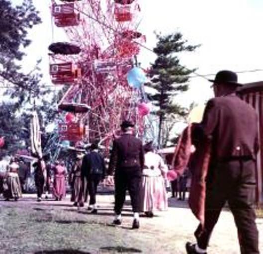 Herbstdult Baron-Schwarz-Park 1968 Koloriertes Foto eines Riesenrades mit Personen die darauf zugehen.